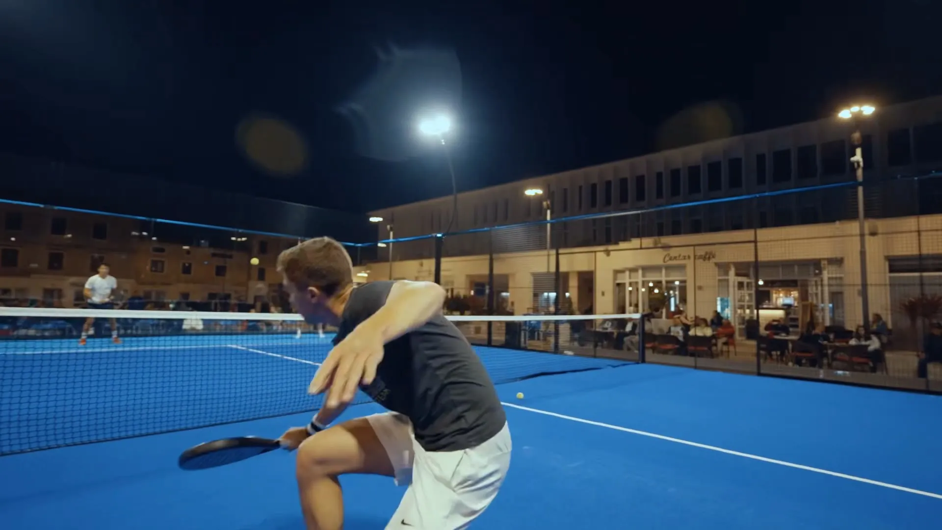 Blick knapp über dem Bodenbelag eines Infinity Court, ein Spieler schlägt