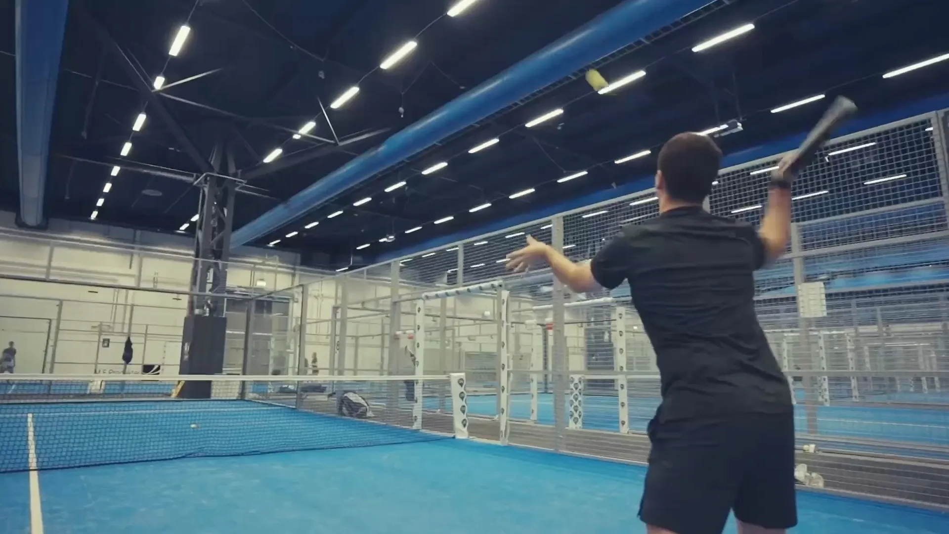 Blick aus dem Inneren eines Panoramic Court auf Augenhöhe, ein Spieler schlägt