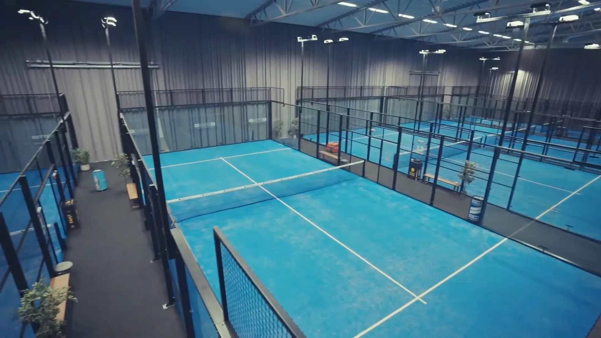 Indoor-Padelhalle mit mehreren Panoramic Courts, Blick entlang der Plätze