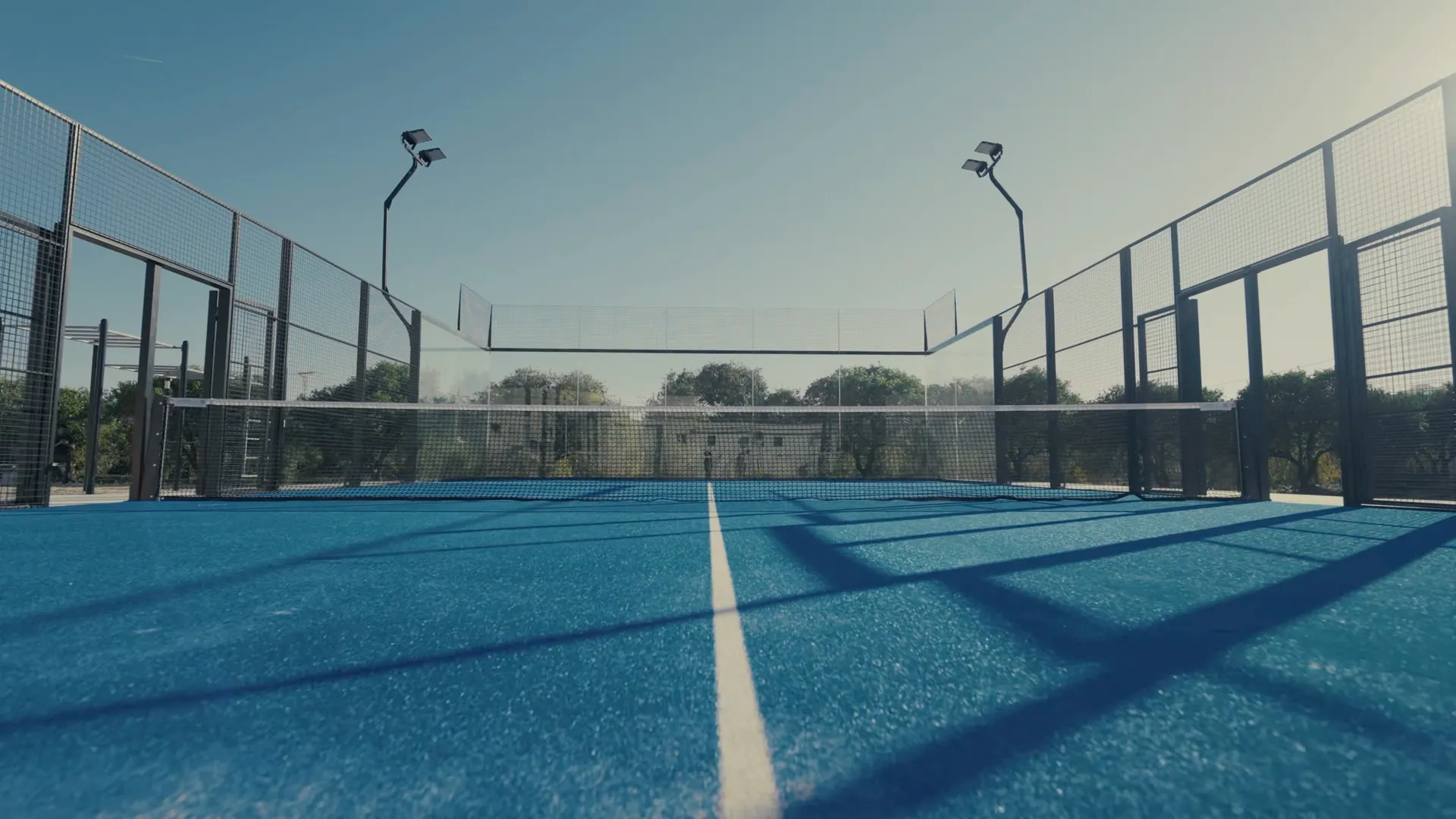 Blick knapp über dem Bodenbelag eines Super Panoramic Court entlang der Mittellinie zum Netz